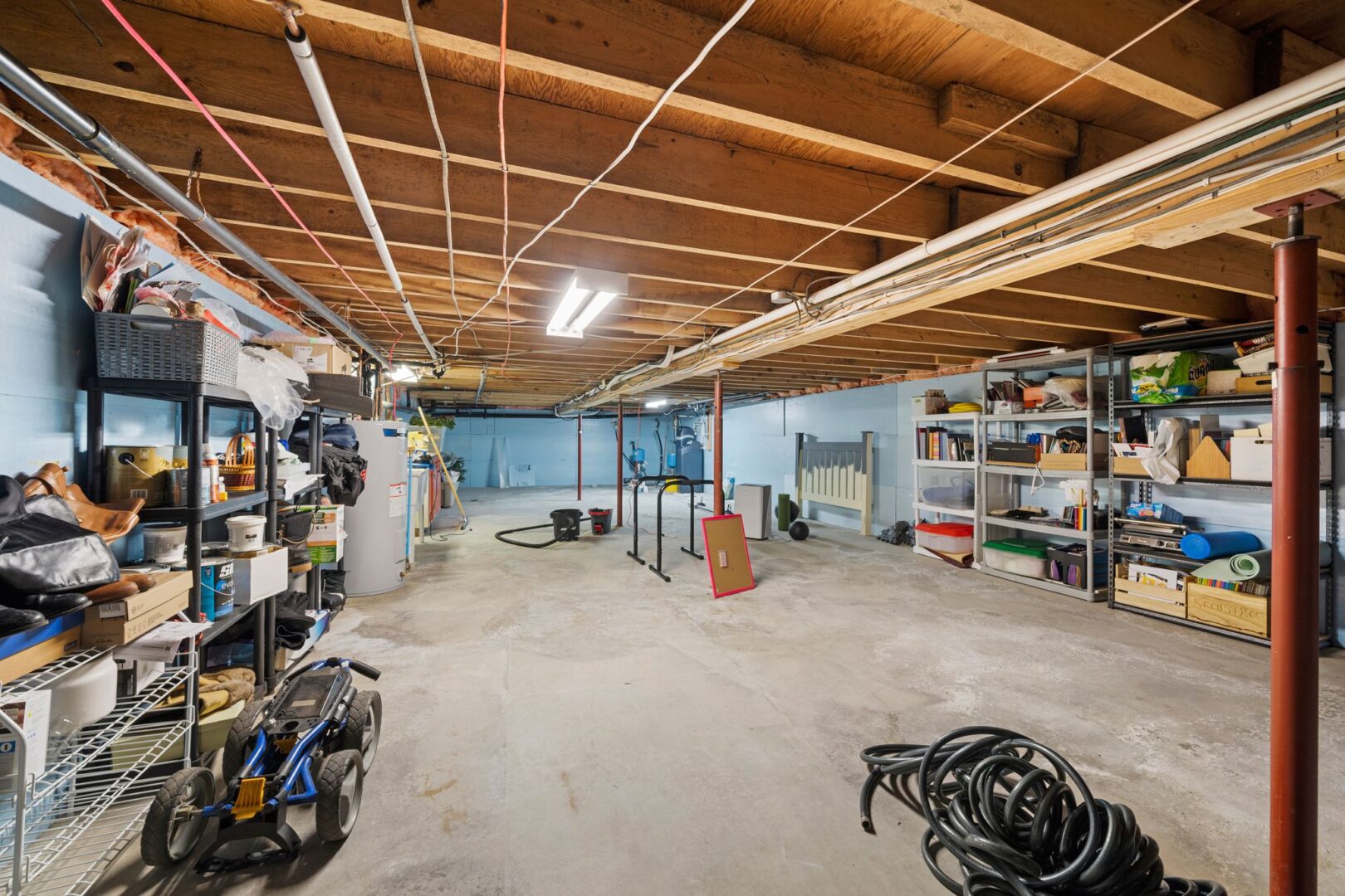 A large, unfinished basement with exposed ceiling beams and a concrete floor.