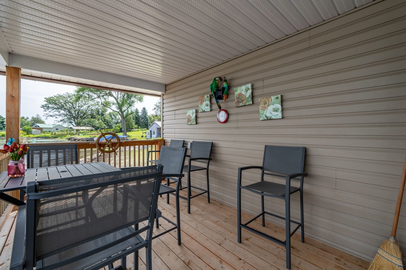 A covered deck with a table and chairs extends off the back of a waterfront bunkie.