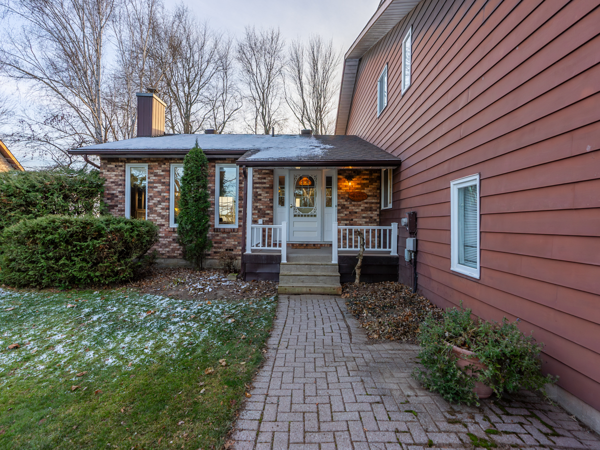 A long stone interlock pathway leads to the front door of a home.