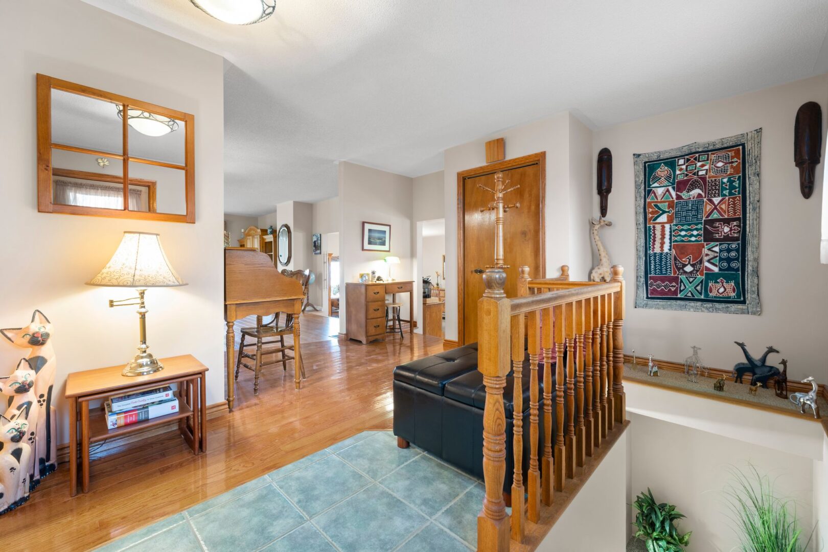 Inside the front entrance of a big bungalow, looking in toward the rest of the house. Stairs off to the right lead down to a basement.