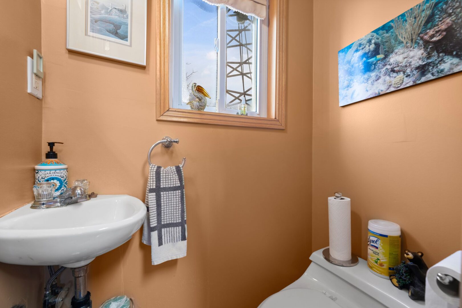 A small bathroom with terracotta-coloured walls, a toilet, and a sink.