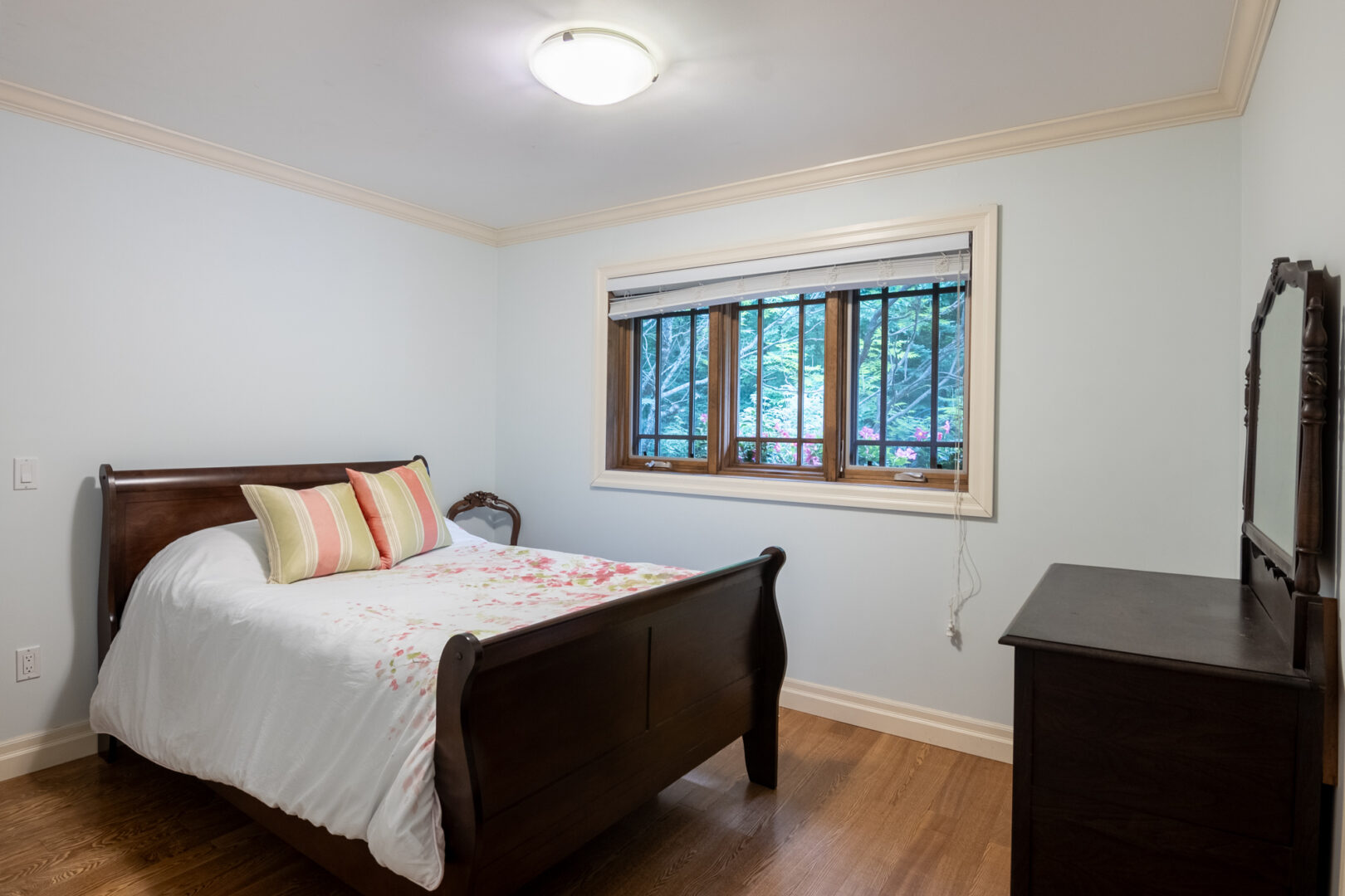 A bedroom with a double bed and a dresser.