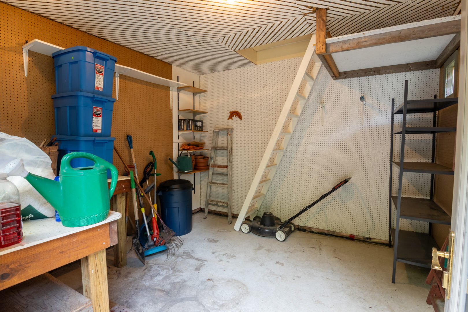 Interior of a small shed with a workshop space.