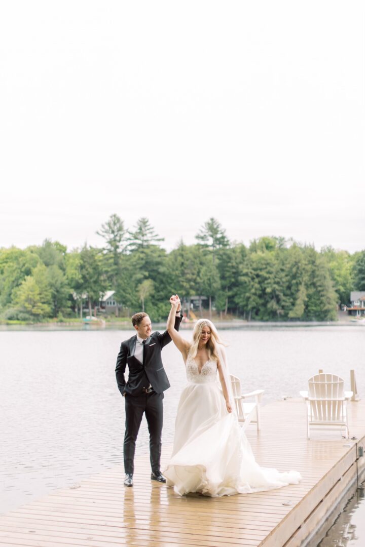 natalie and her husband hold hands on the dock