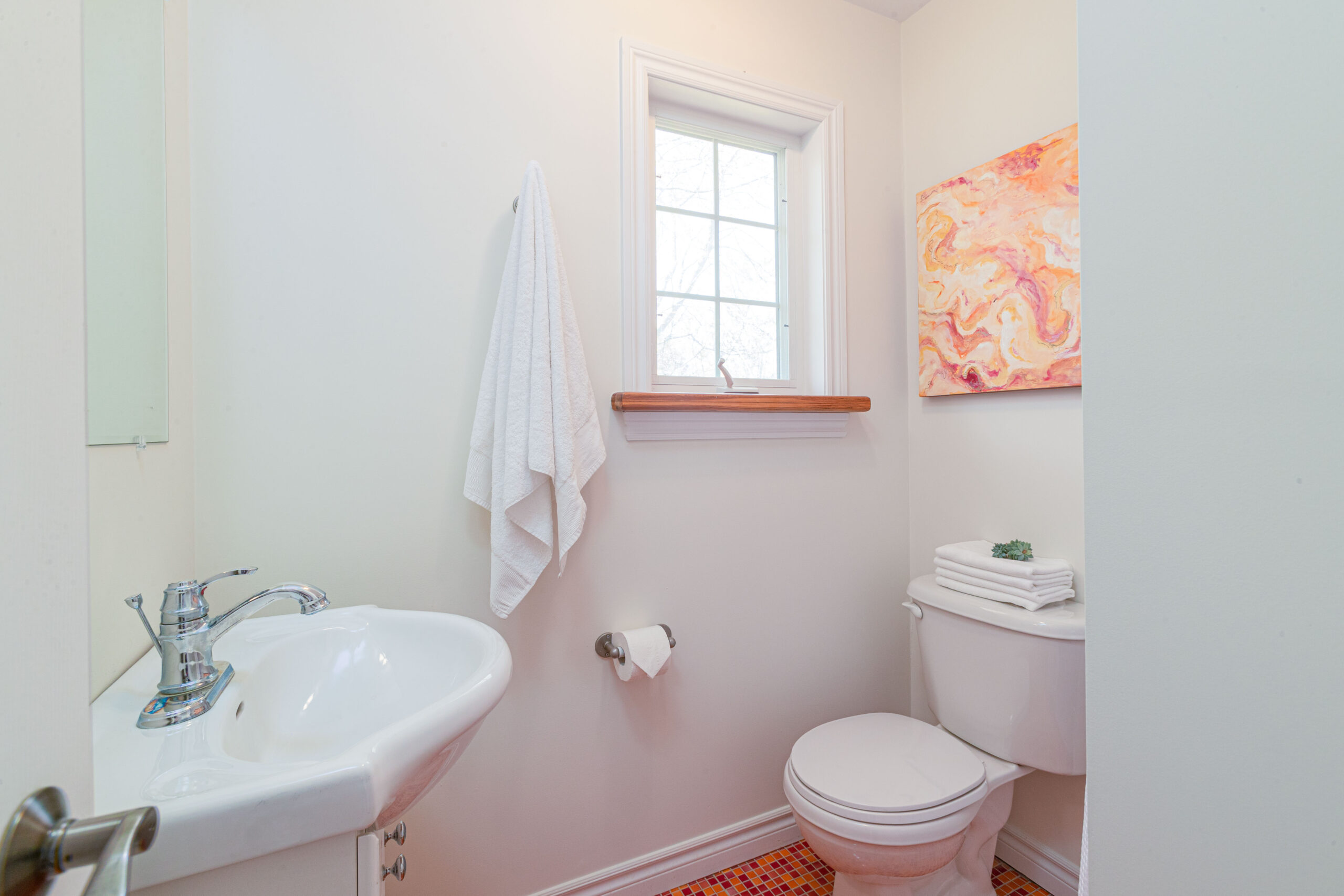 A bright bathroom with a toilet and a sink.