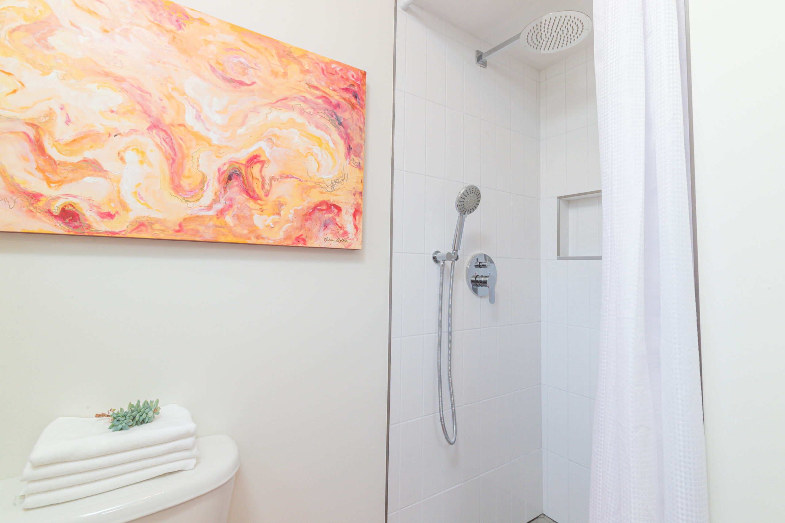 A small walk-in shower with a curtain, in a bathroom.