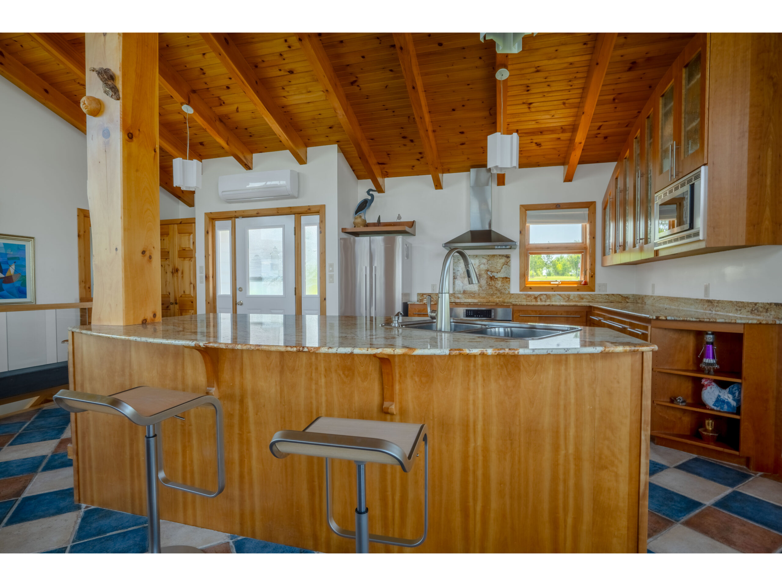 A big kitchen island with a granite countertop and barstools.