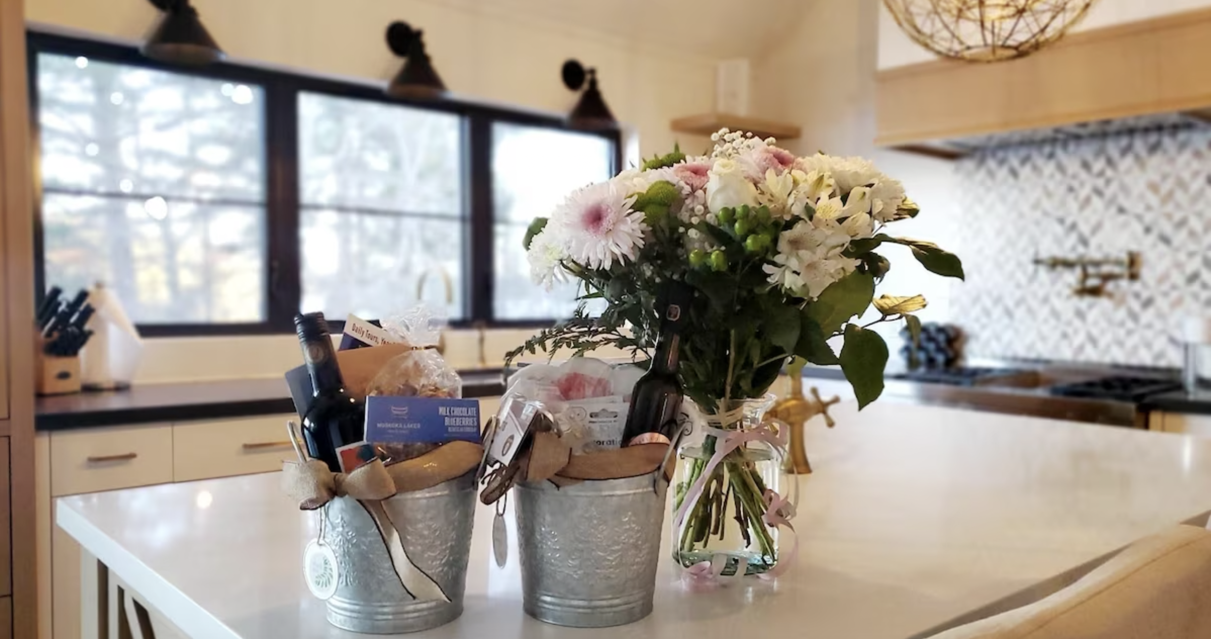 two gift buckets with champange and candies with a flower bouquet