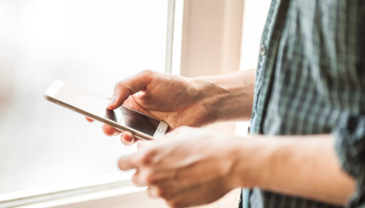 Man holding mobile phone in his hands, using mobile phone close-up shot. Man dialling a hotline number on his phone