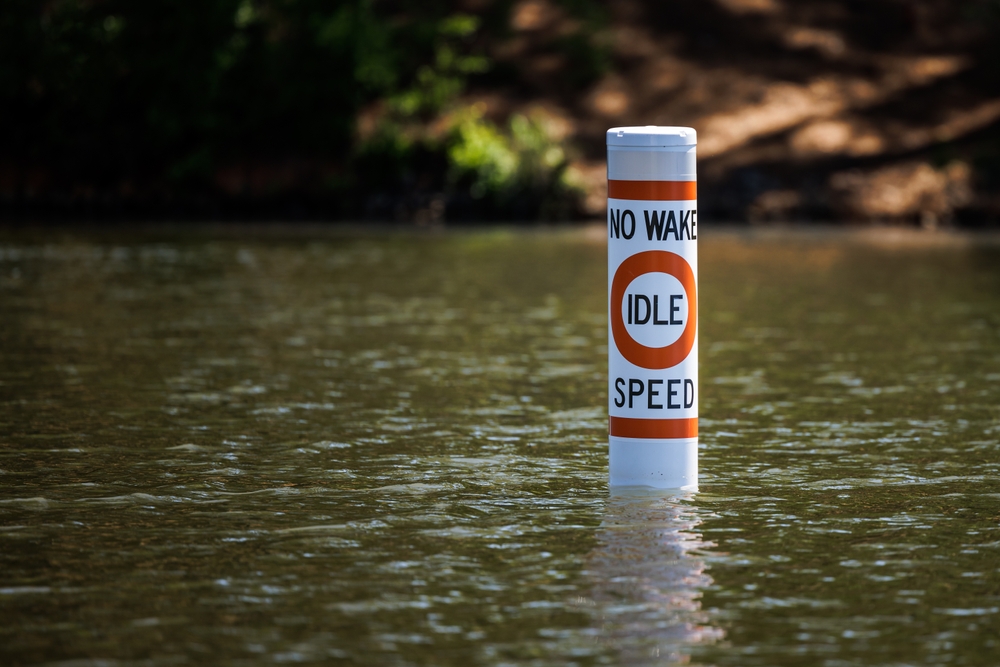 No wake safety buoy on lake alerting boaters to idle speed restriction.