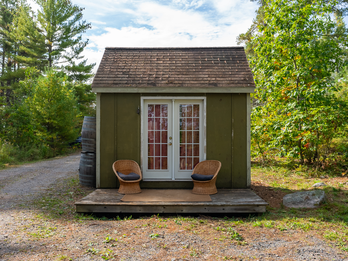 Exterior of sauna is green with French doors