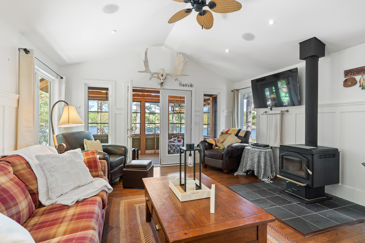 Red and yellow couch faces the wood stove and TV mounted high up on the wall