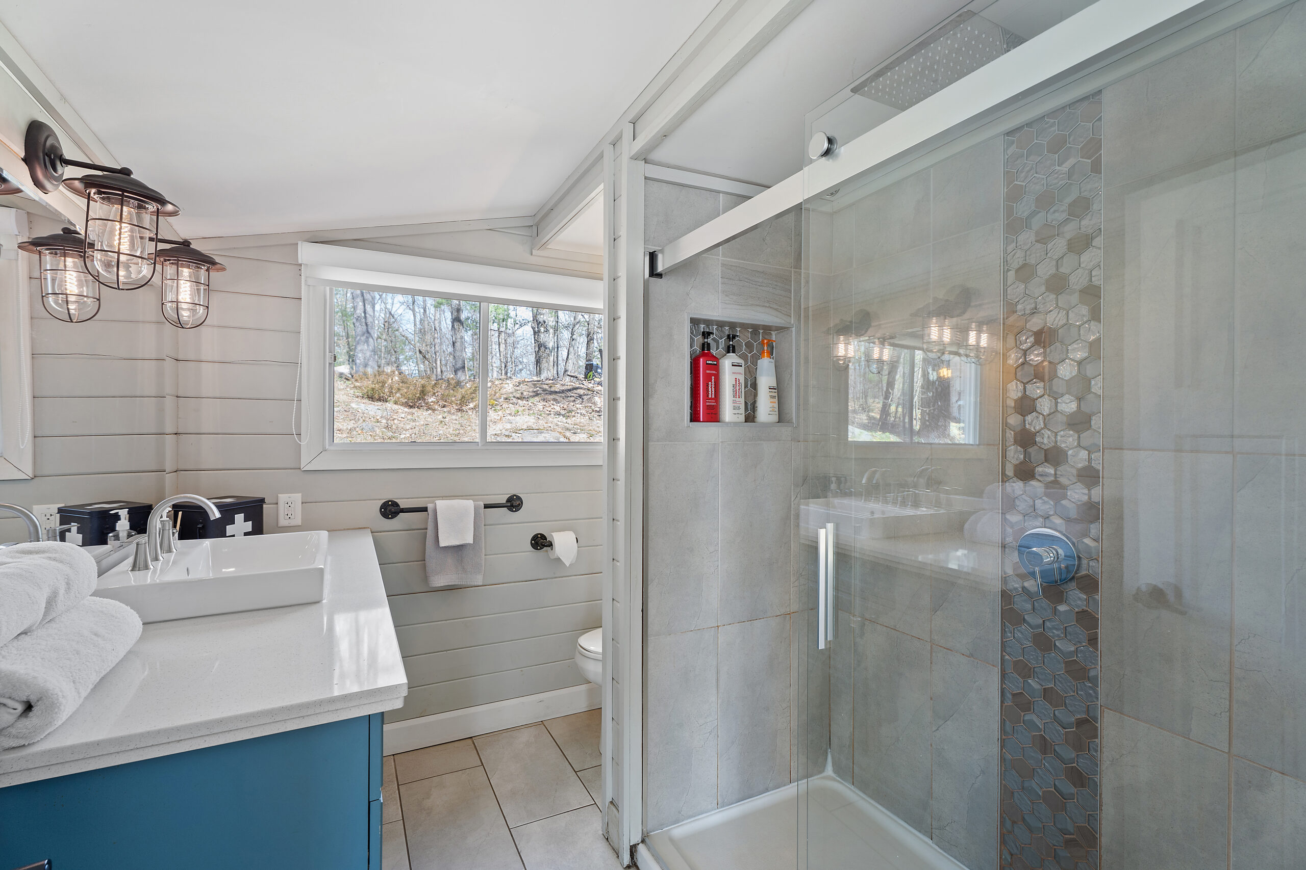 A white sink is across from a glass walk-in shower