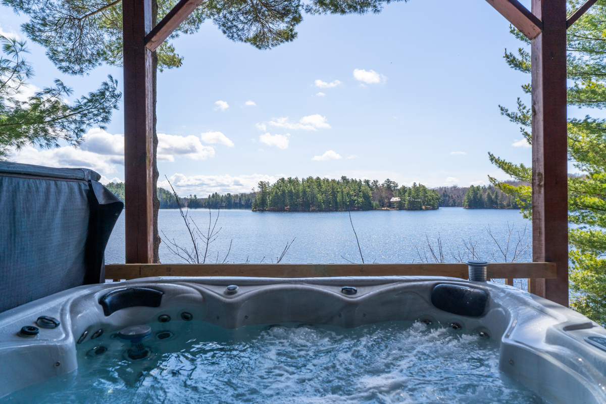A hot tub with the jets on looks onto the lake