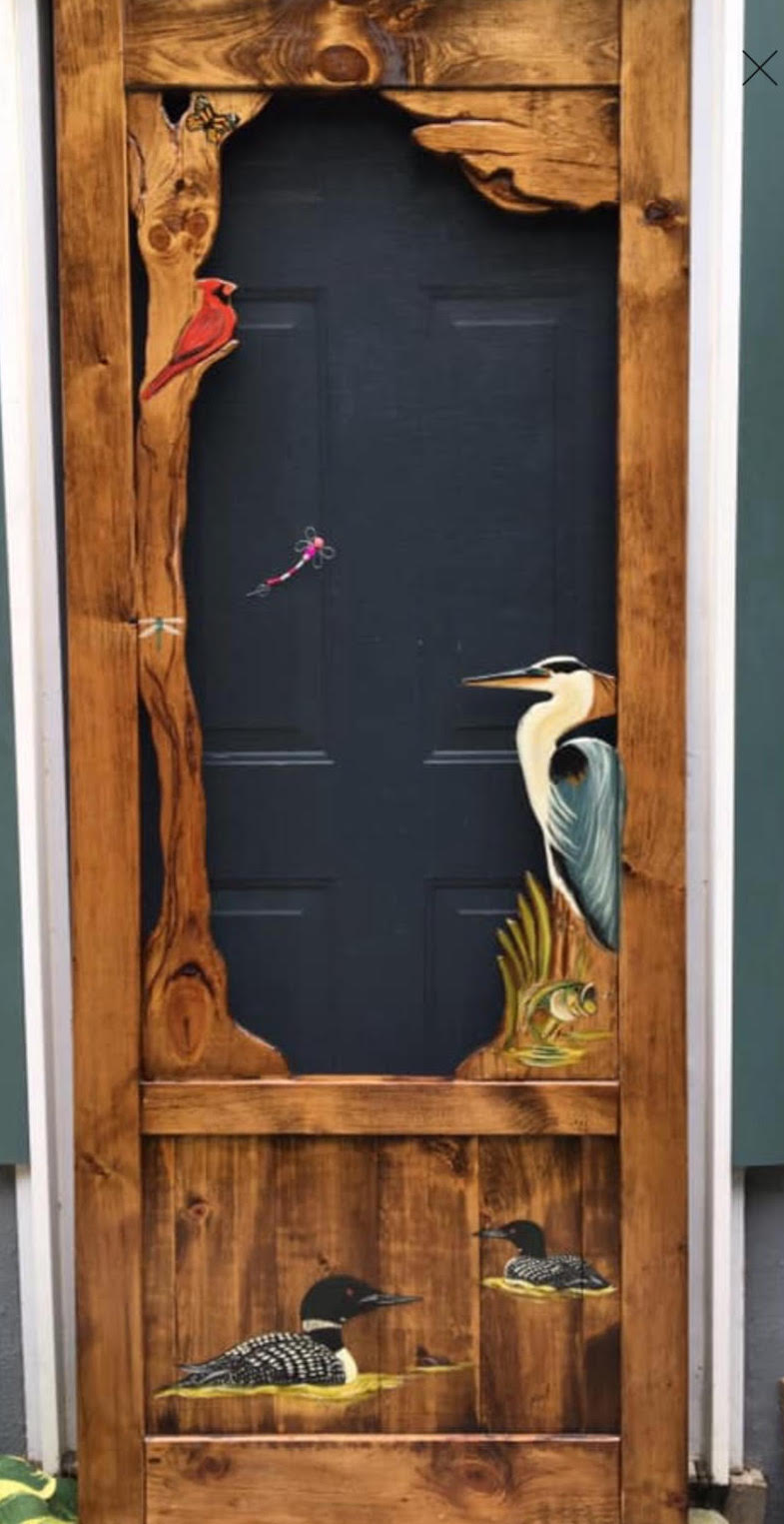 A brown screen door with loons, blue herrings and cardinals painted on