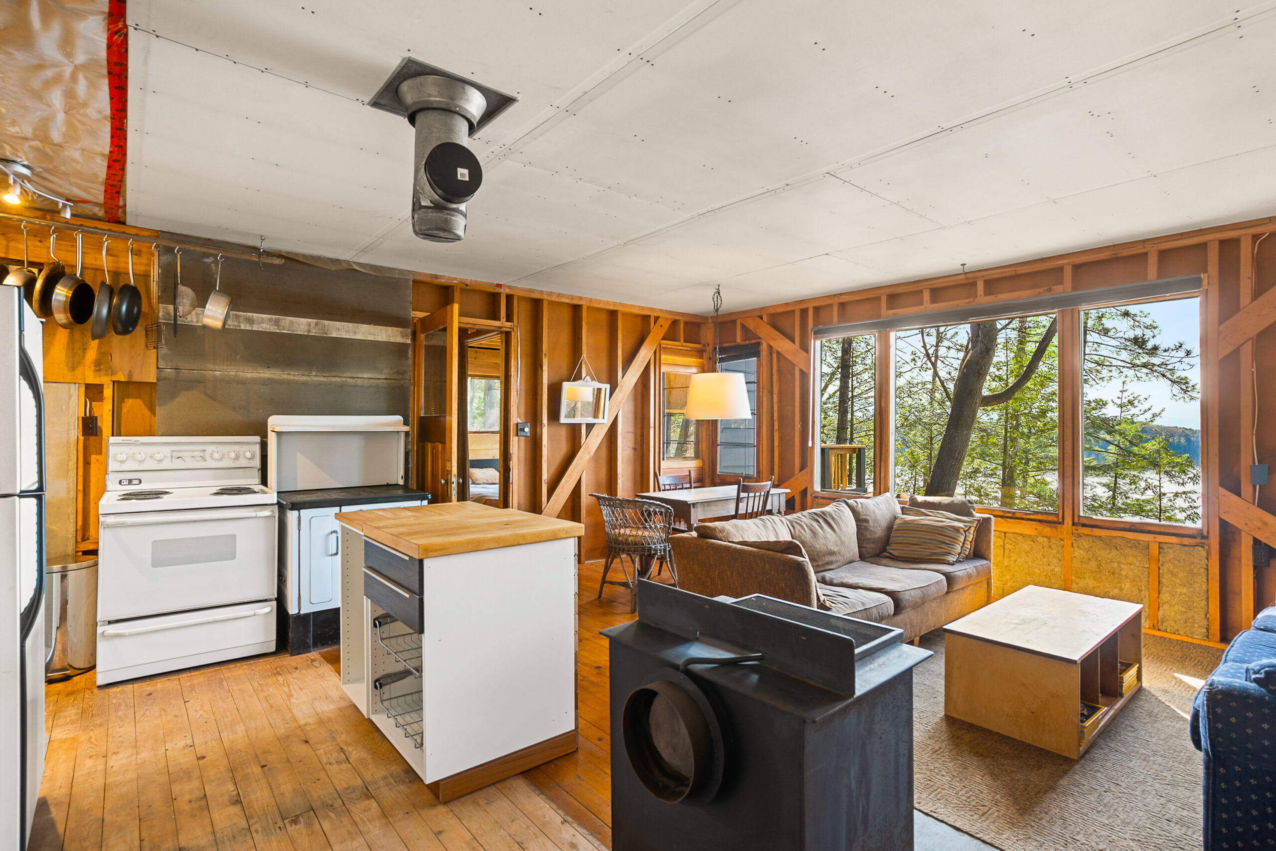 A small white kitchen island leads into an open concept living area