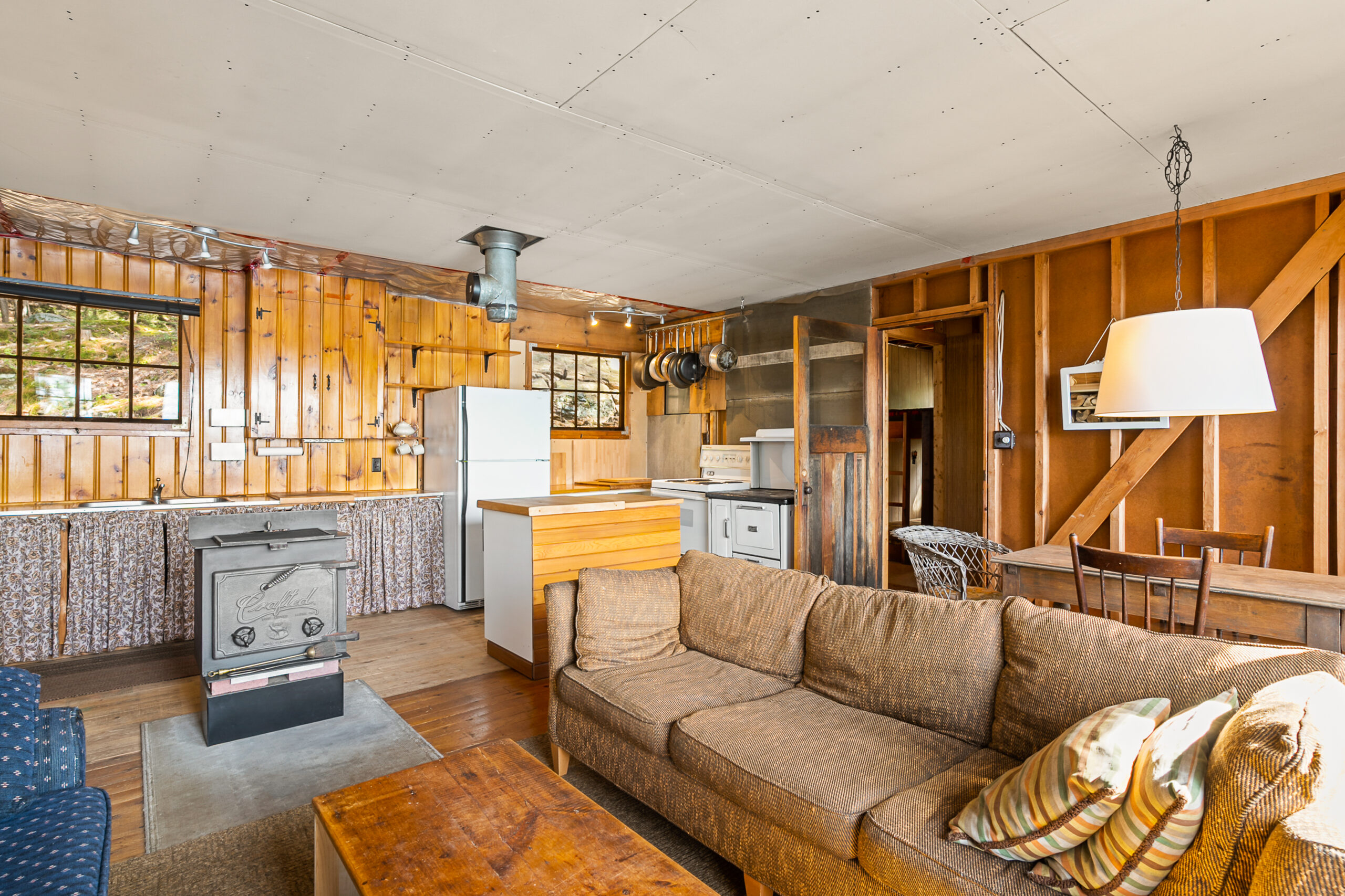 A brown couch perpendicular to the ktichen