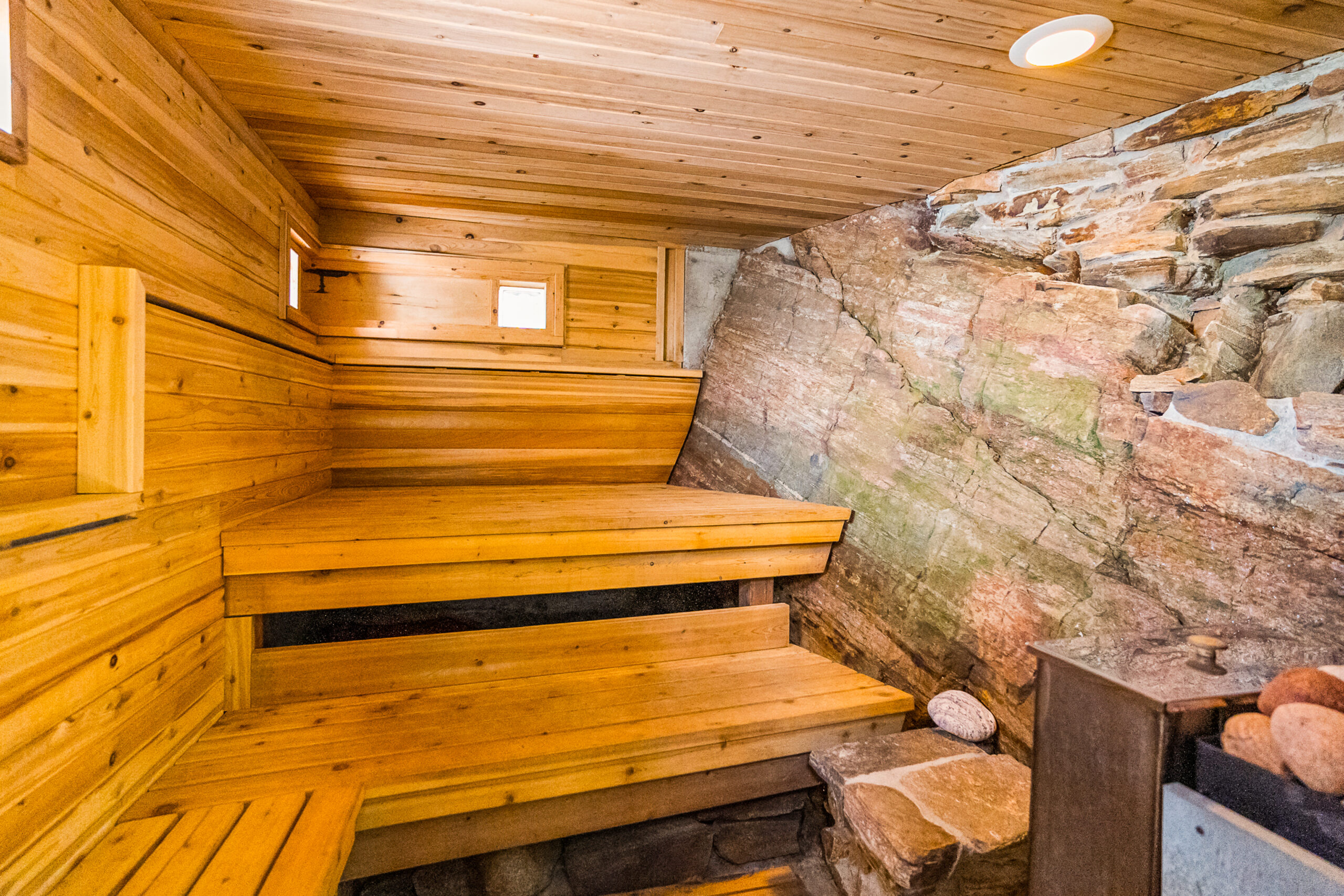 Raised, wood panelled benches next to a large boulder
