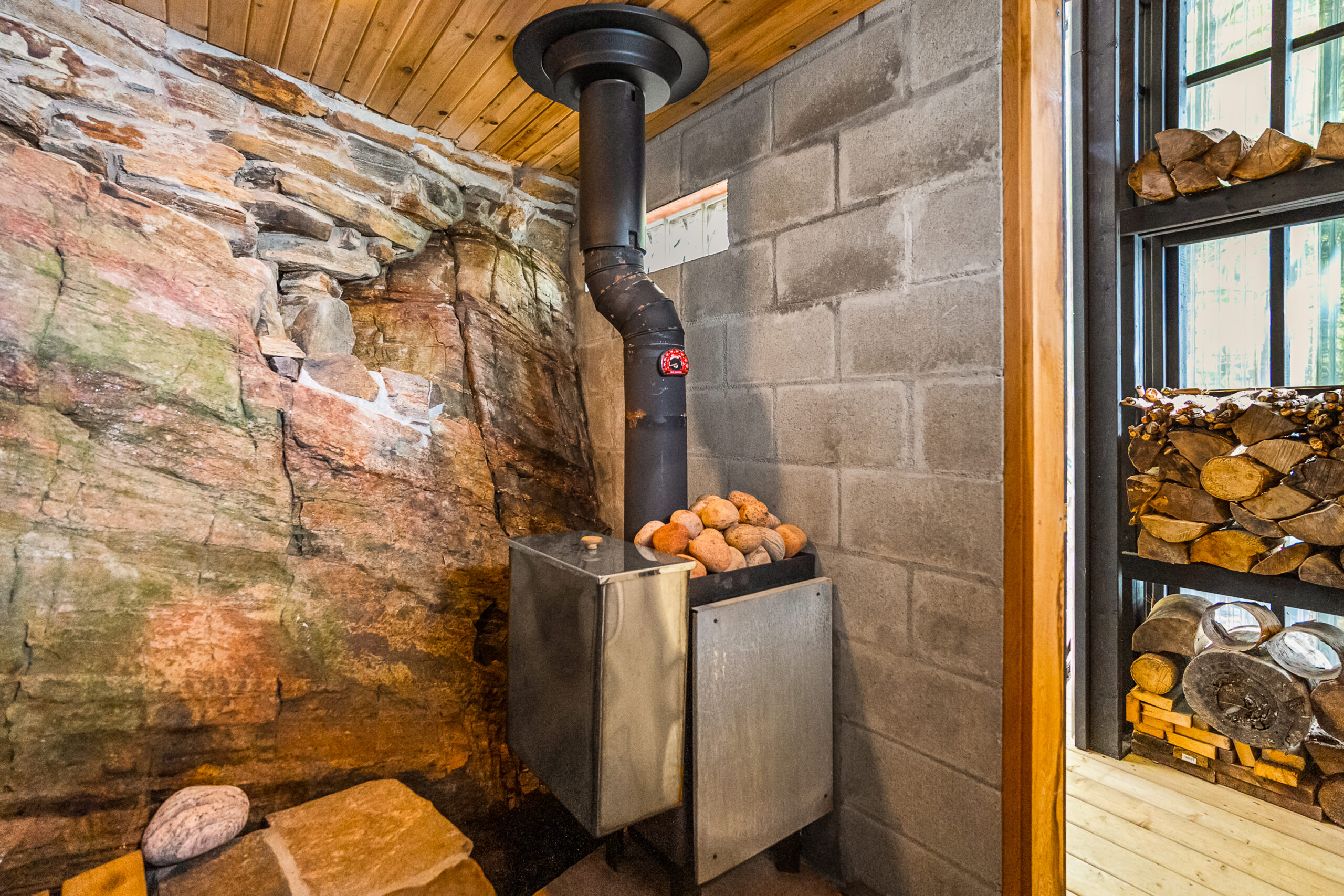 A boulder is built into the side of the sauna, next to the heating unit