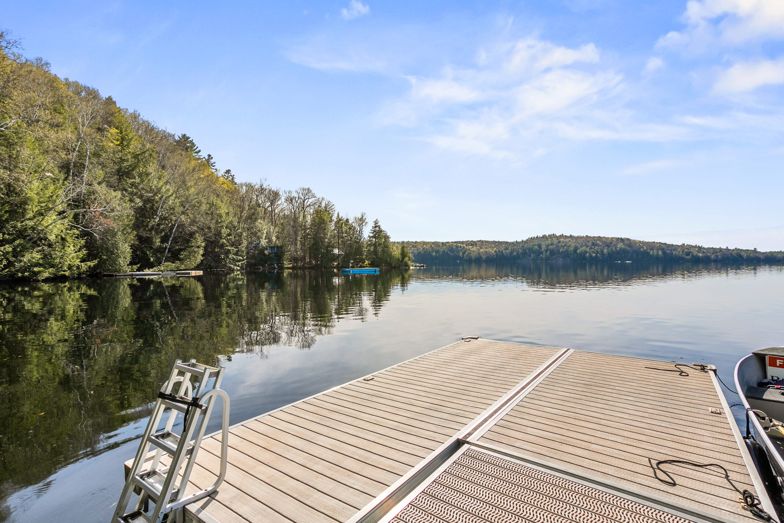 From the end of the dock, views to the tree-lined blue lake