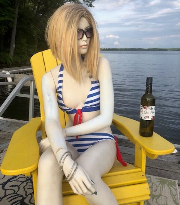 A mannequin sitting in a dock chair
