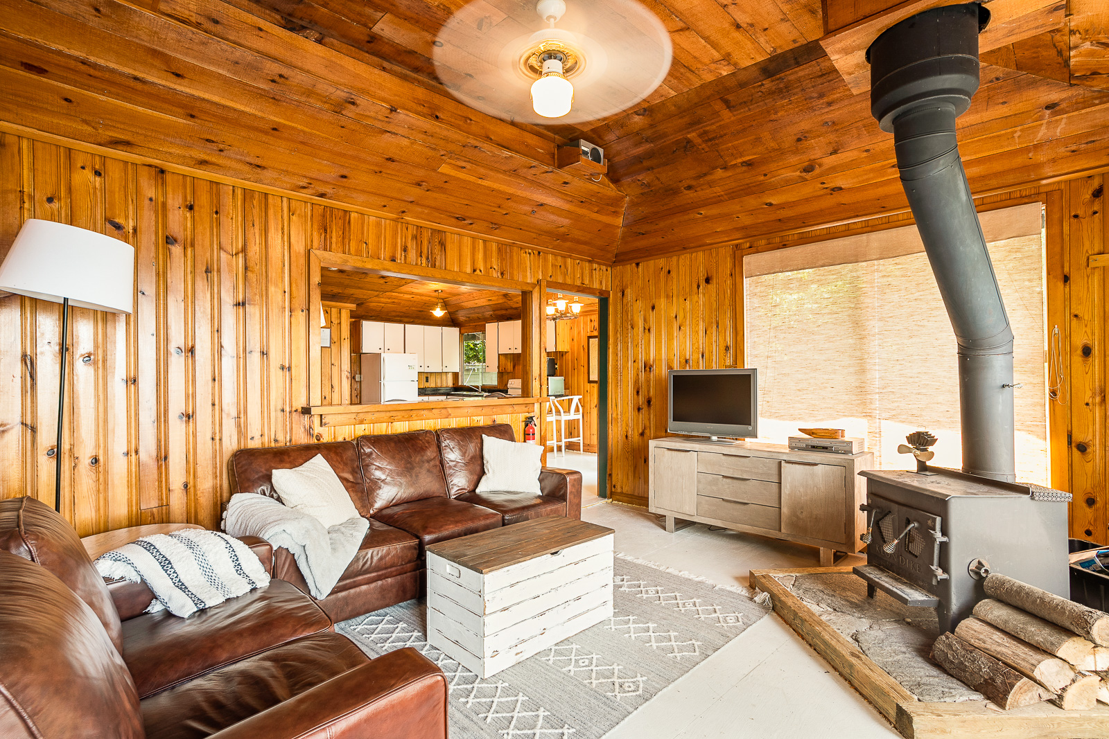 A living room with brown leather couches, a small table and overhead lighting