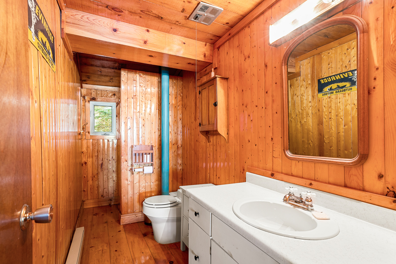 A brown wood-paneled bathroom with a white vanity