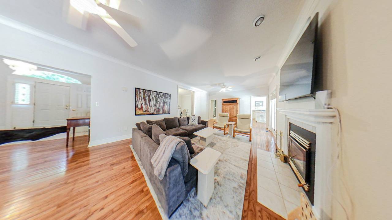 A grey couch faces a fireplace and flat screen TV