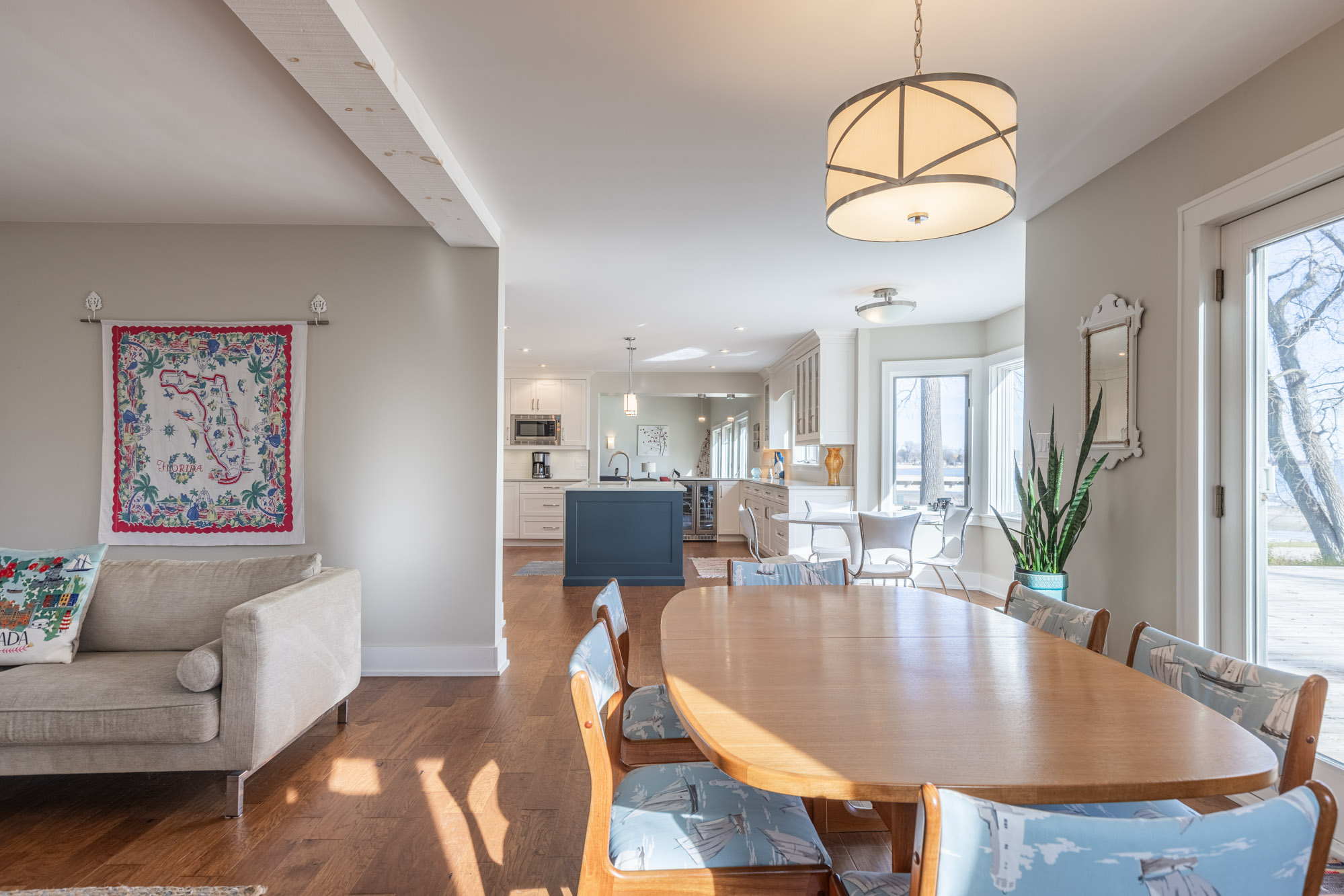 A brown wood dining table and wood chairs with blue cushions face the dining area