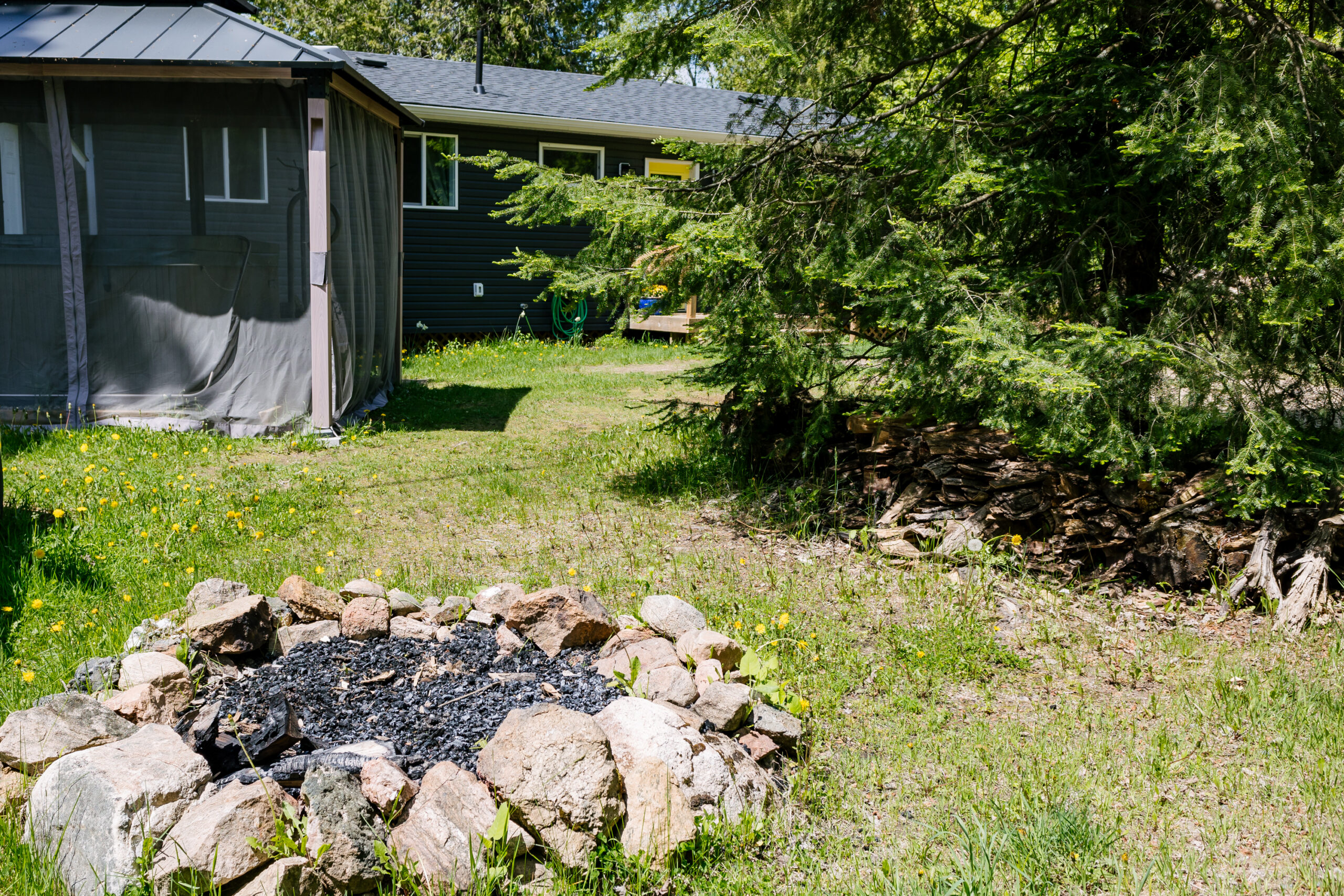 A red lined fire pit sits on the grass