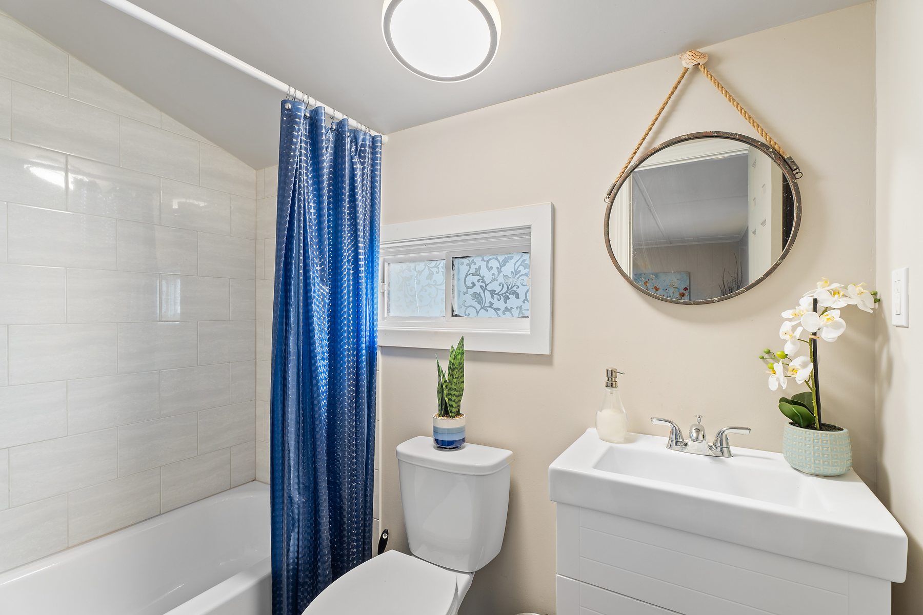 A three-piece bathroom with a toilet, a sink, and a shower-tub combo.
