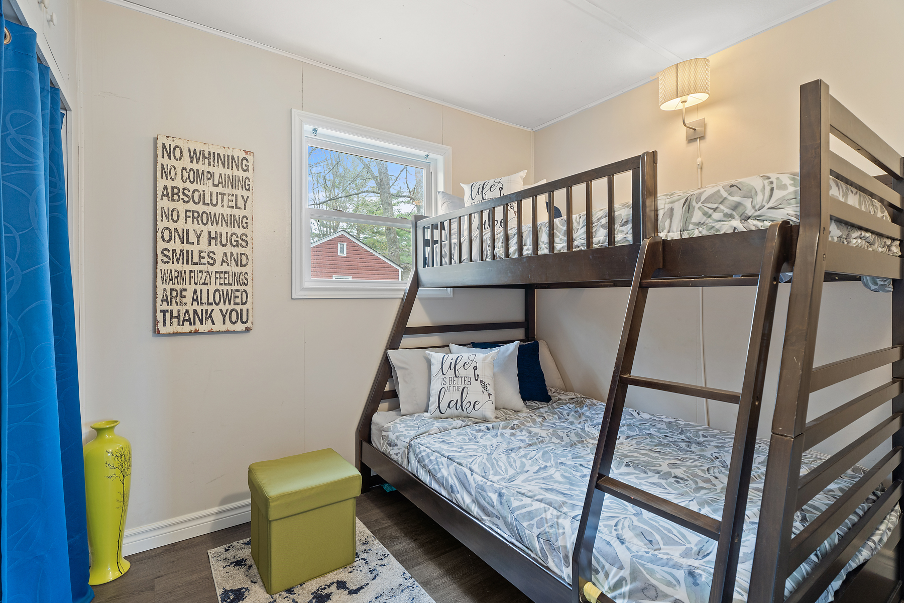 A small, bright bedroom with a window and bunkbeds.