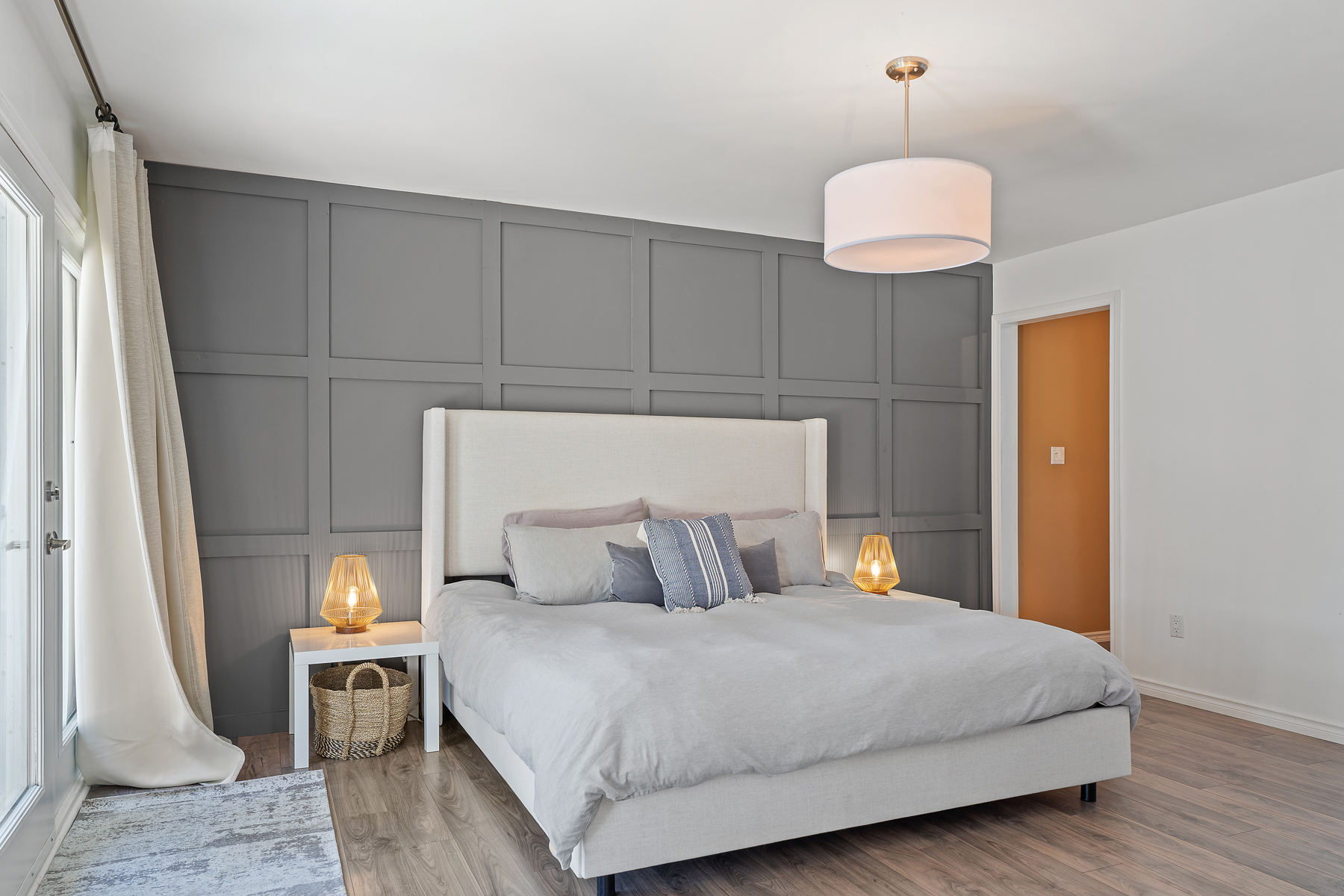 A white bed and bedroom sit against a grey wall