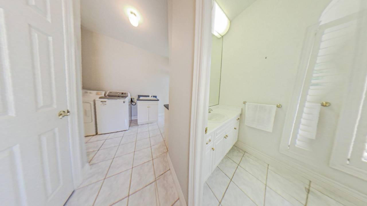 A white laundry room next to a white bathroom