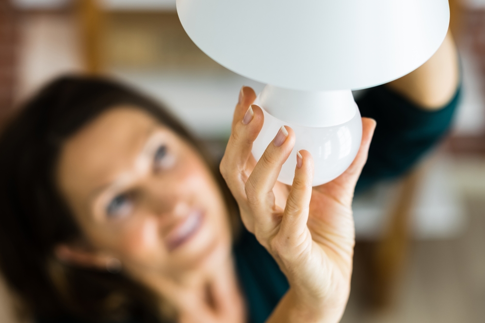 A woman replacing a lightbulb