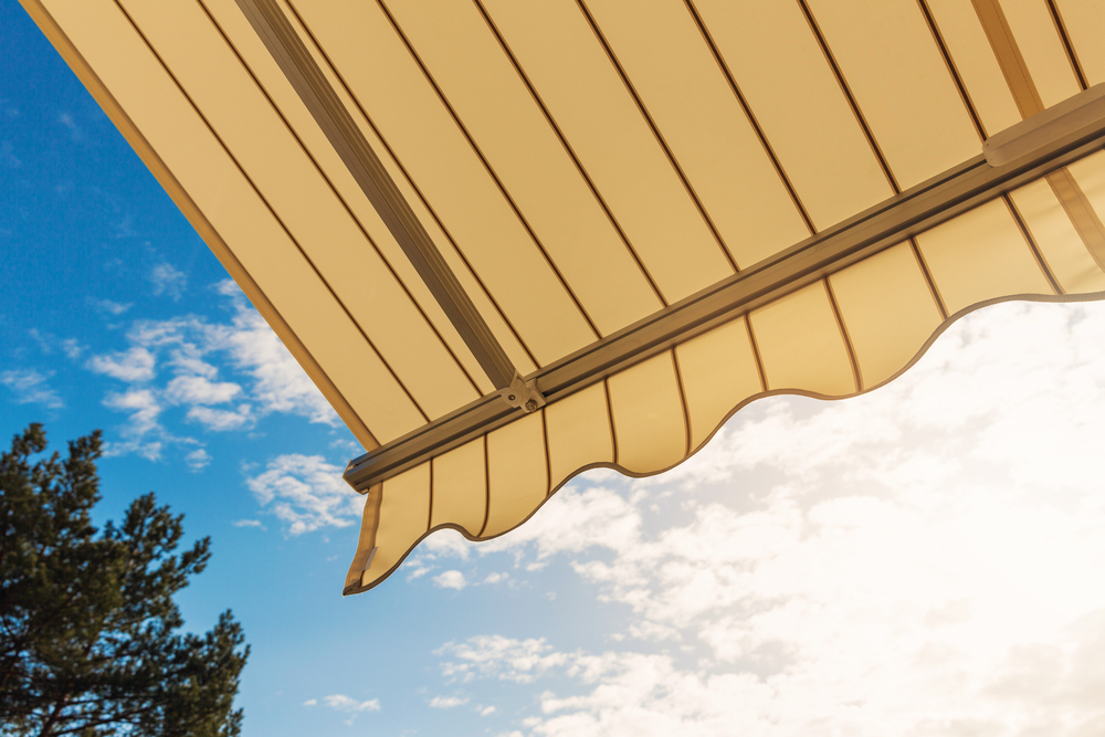 An awning, photographed from underneath, against a blue sky