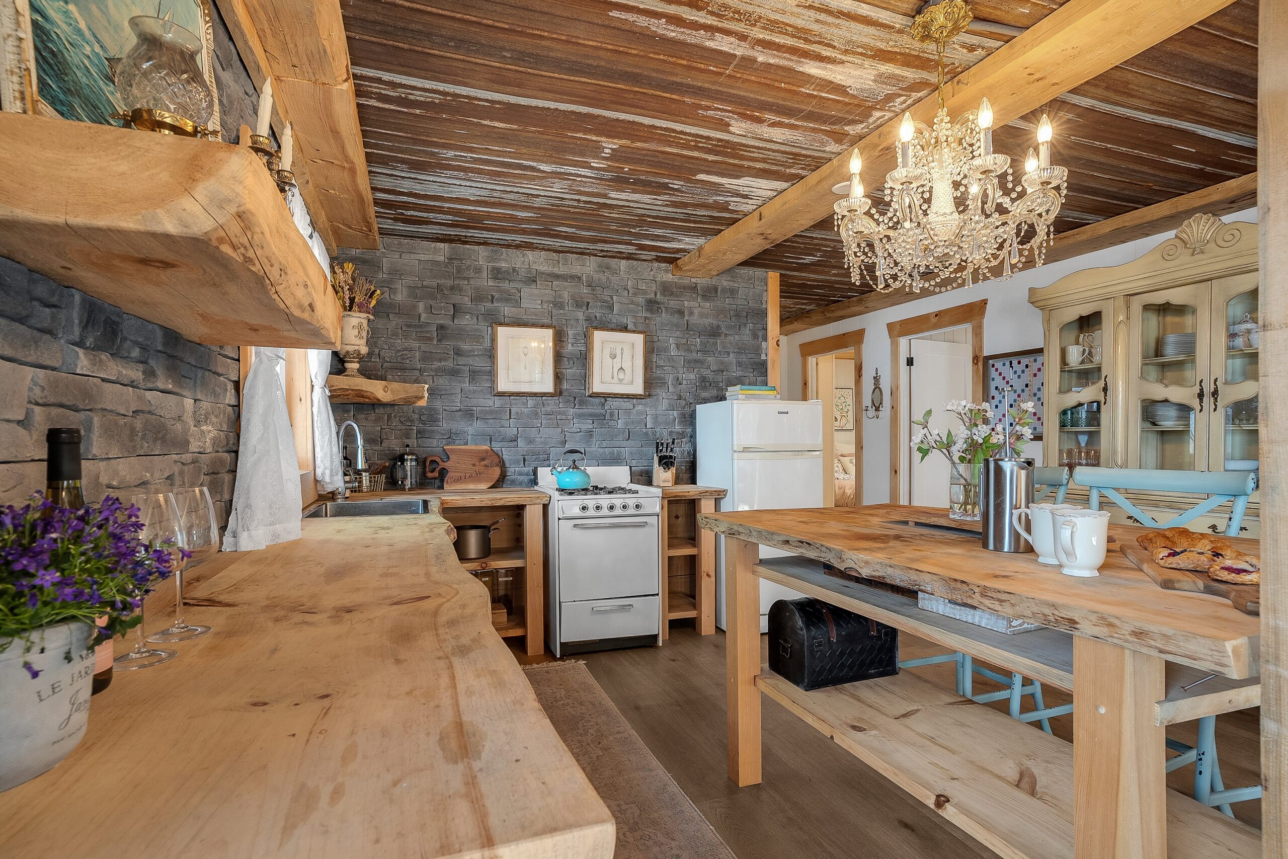 A wood countertop along the left wall faces a kitchen island