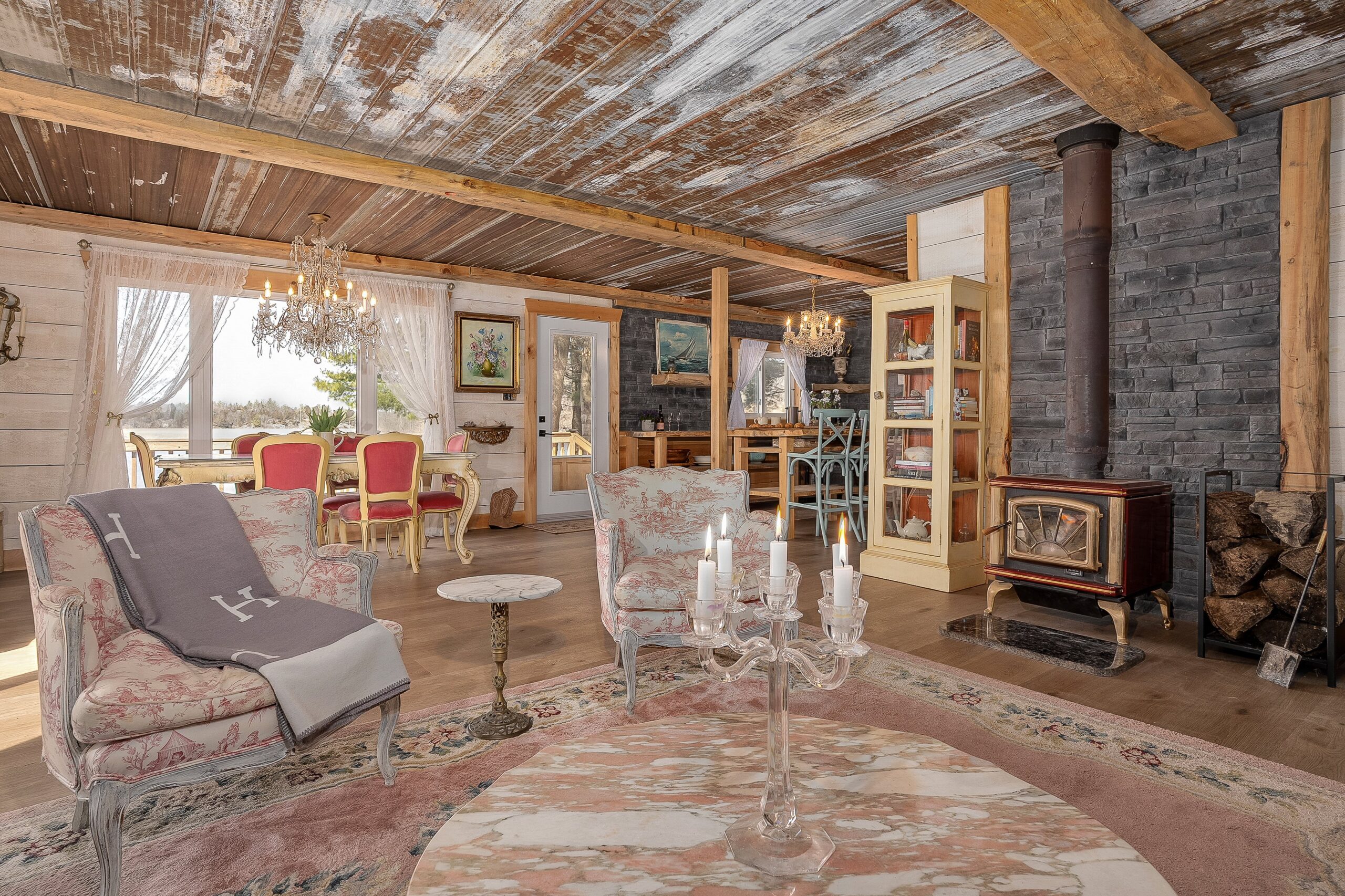 Two pink and white chairs on a pink rug. Behind, an open-concept dining room