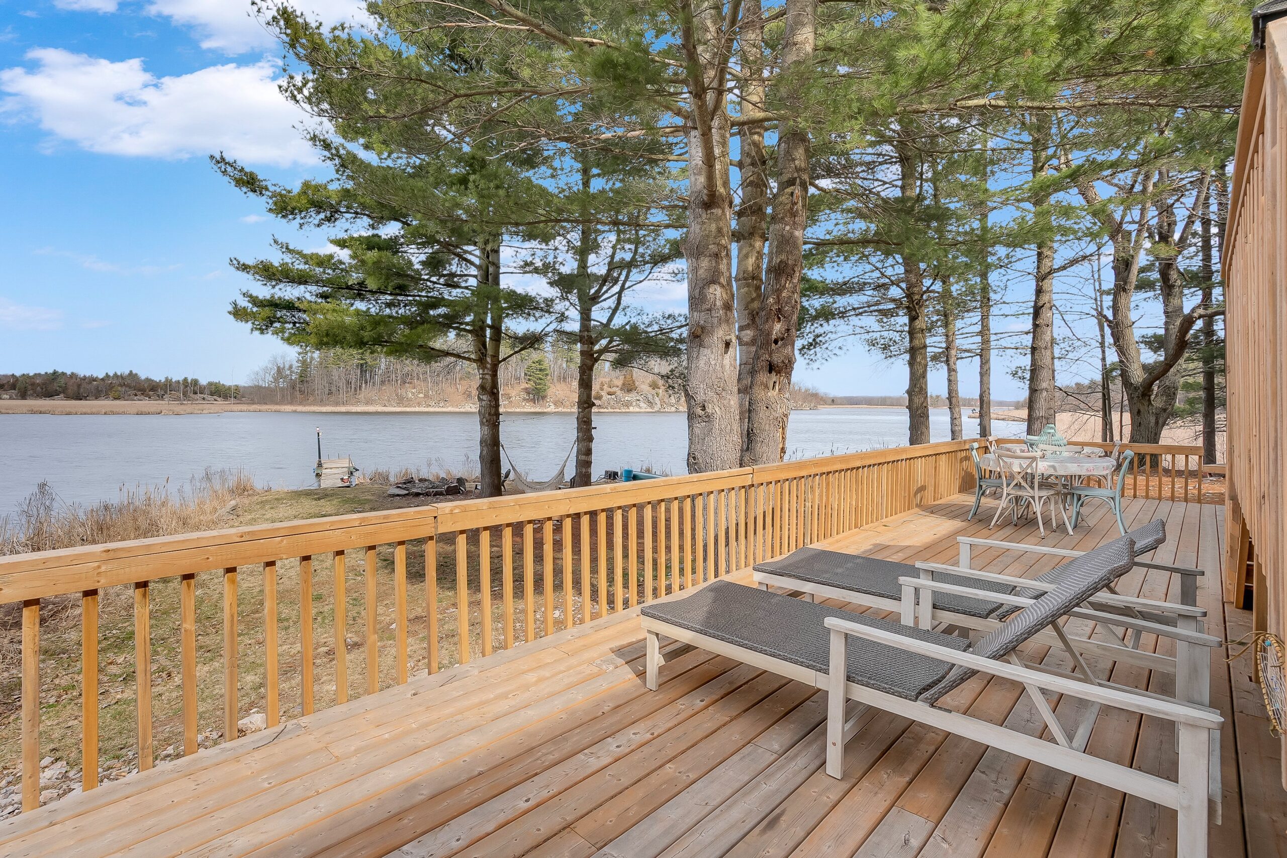 Grey lounge chairs on the deck face out towards the river