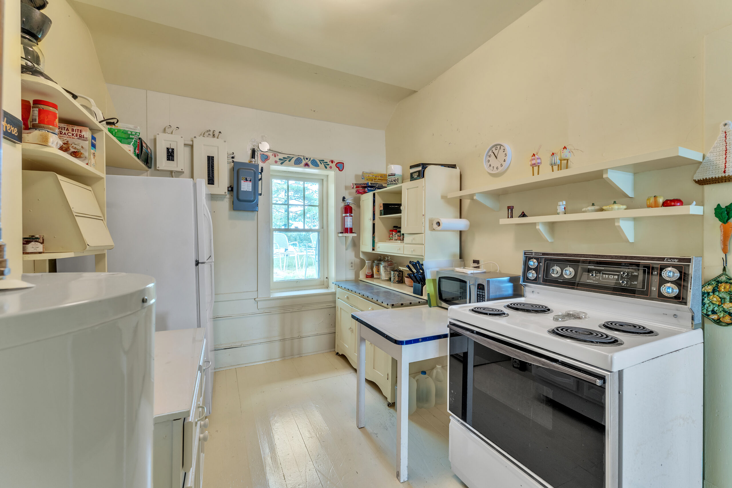 To the right, a white stove, prep area and cabinets. On the left, a white fridge