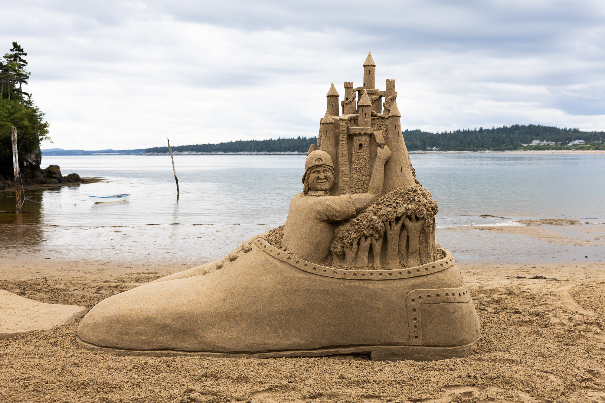 A sand sculpture of a castle coming out of a shoe
