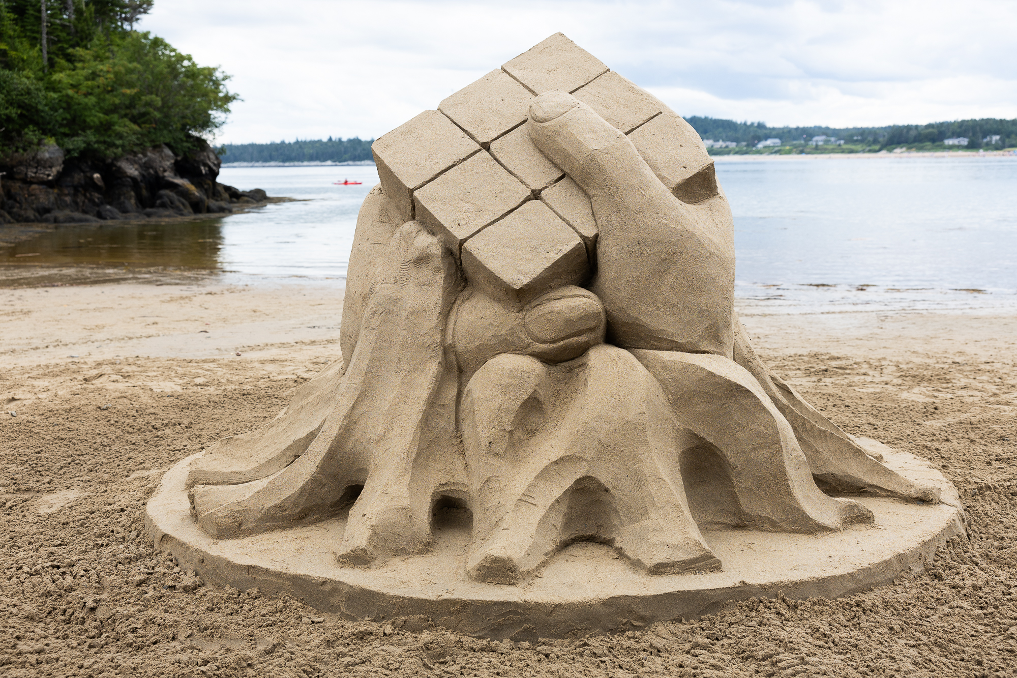 A sculpture of a hand holding a Rubix cube