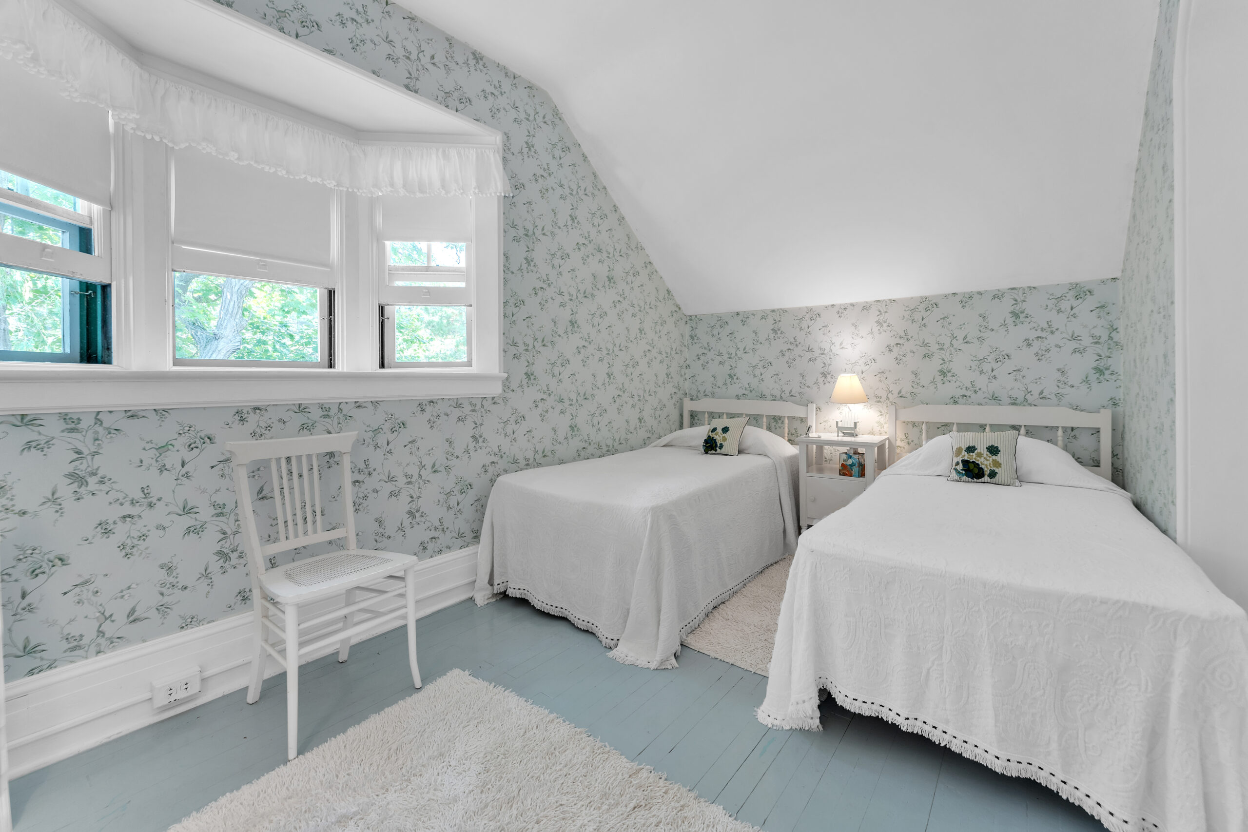 Two white twin beds in a patterned room