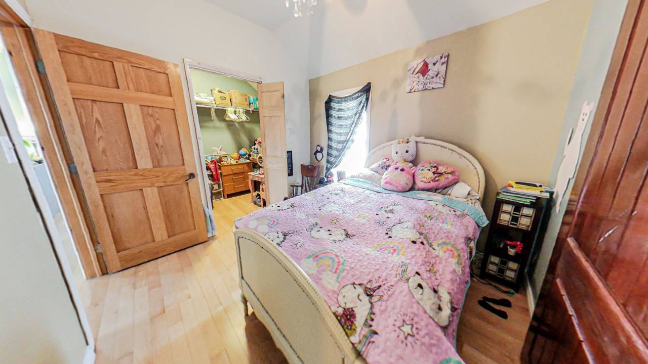 A pink bed on a white bed frame in a bedroom