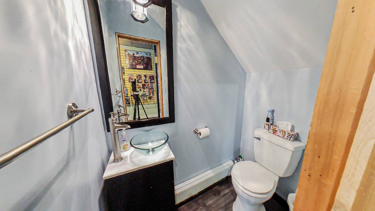 A brown wood vanity with a mirror above next to a toilet