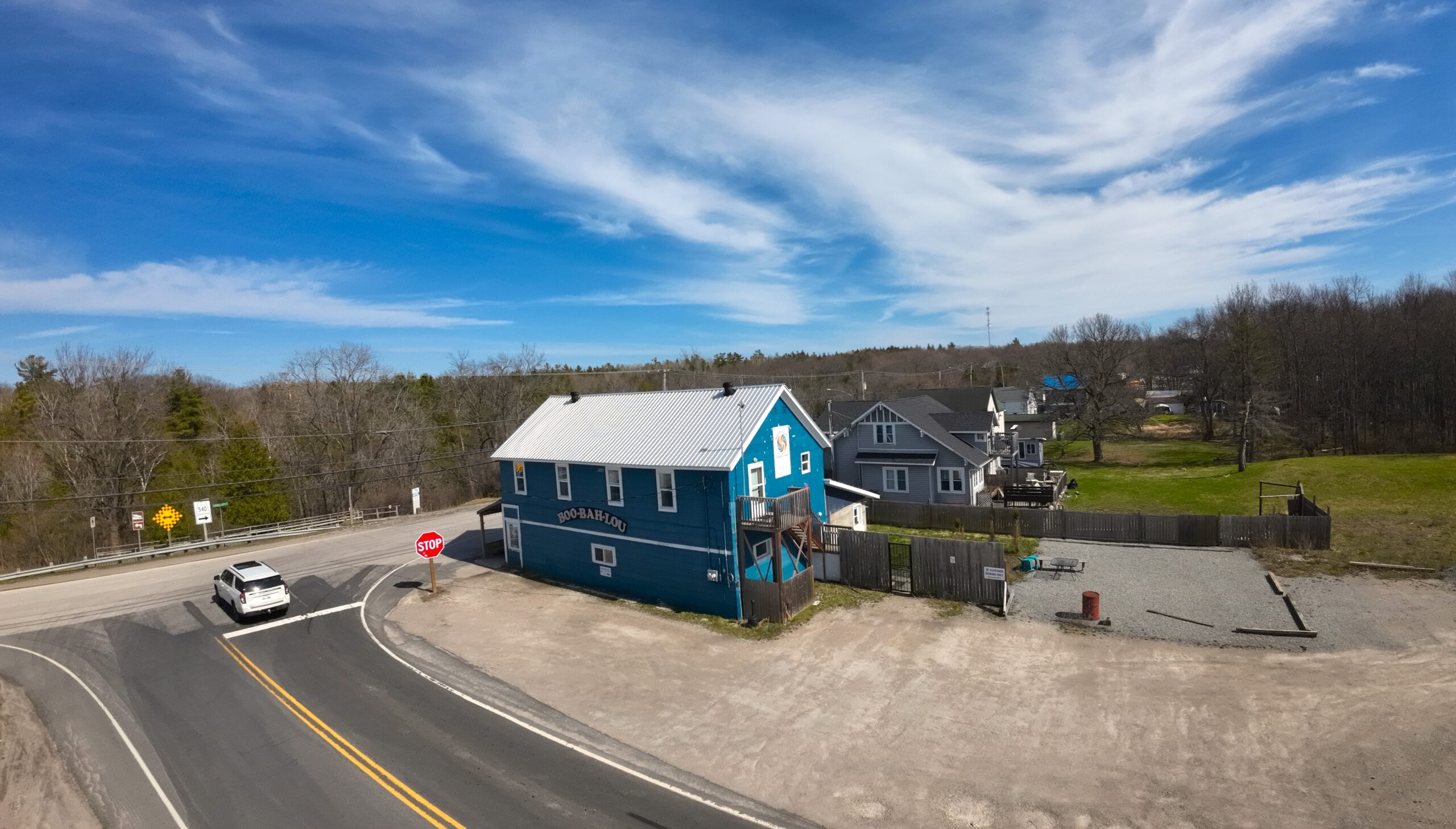 Aerial shot of a two-story blue building at a corner intersection