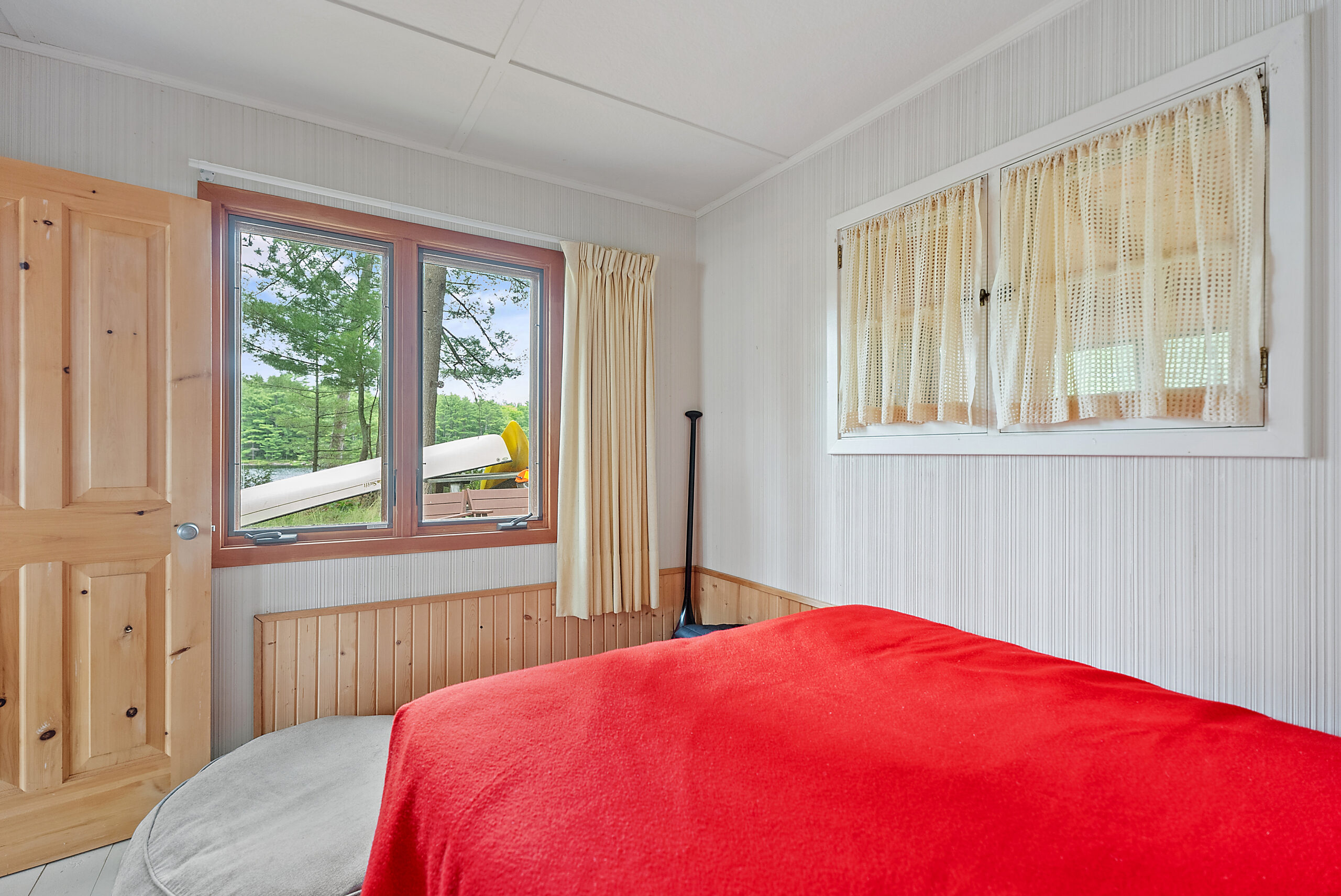 A red bed faces a bright window