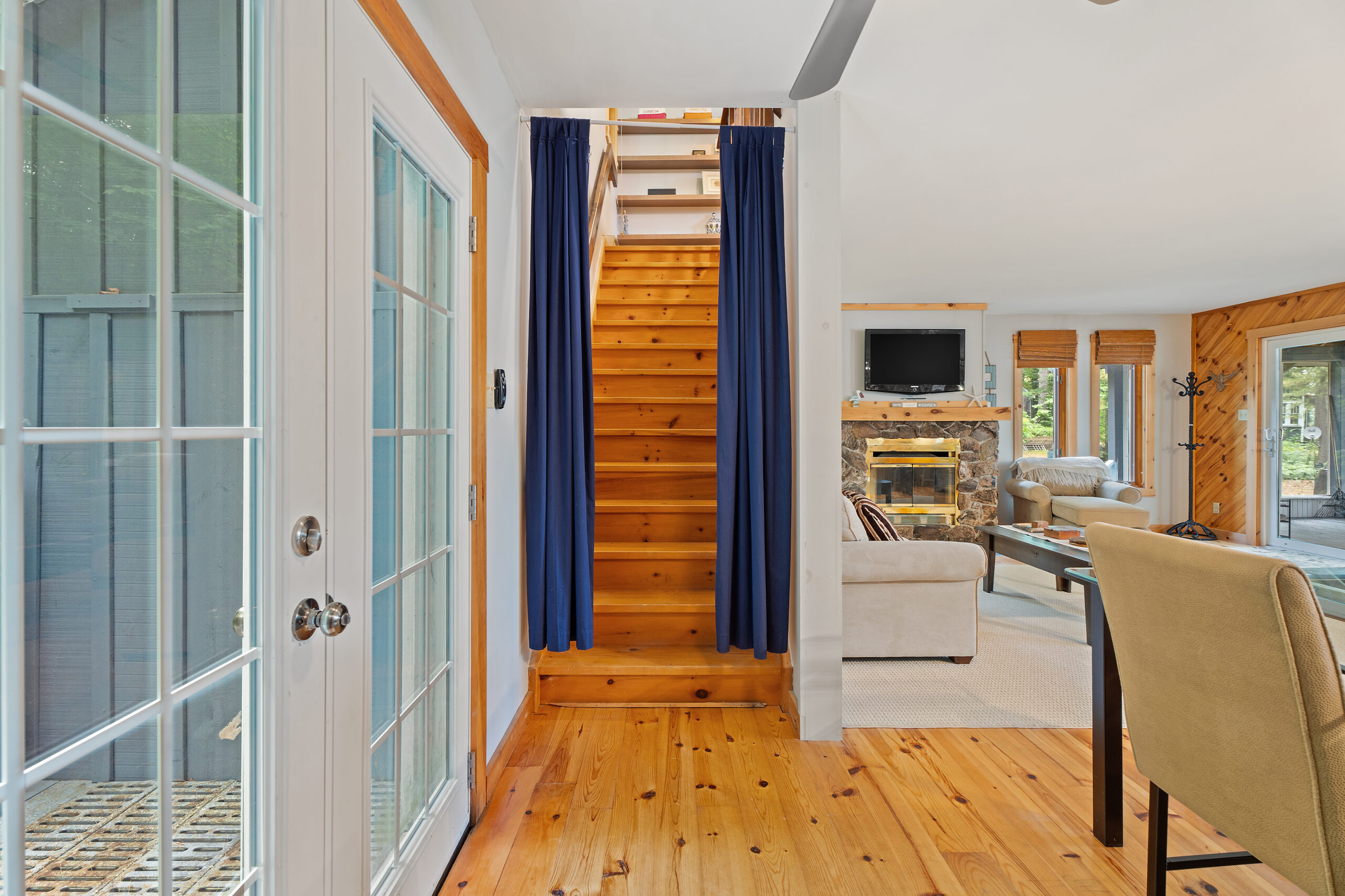 Brown wood stairs with blue curtains framing the staircase