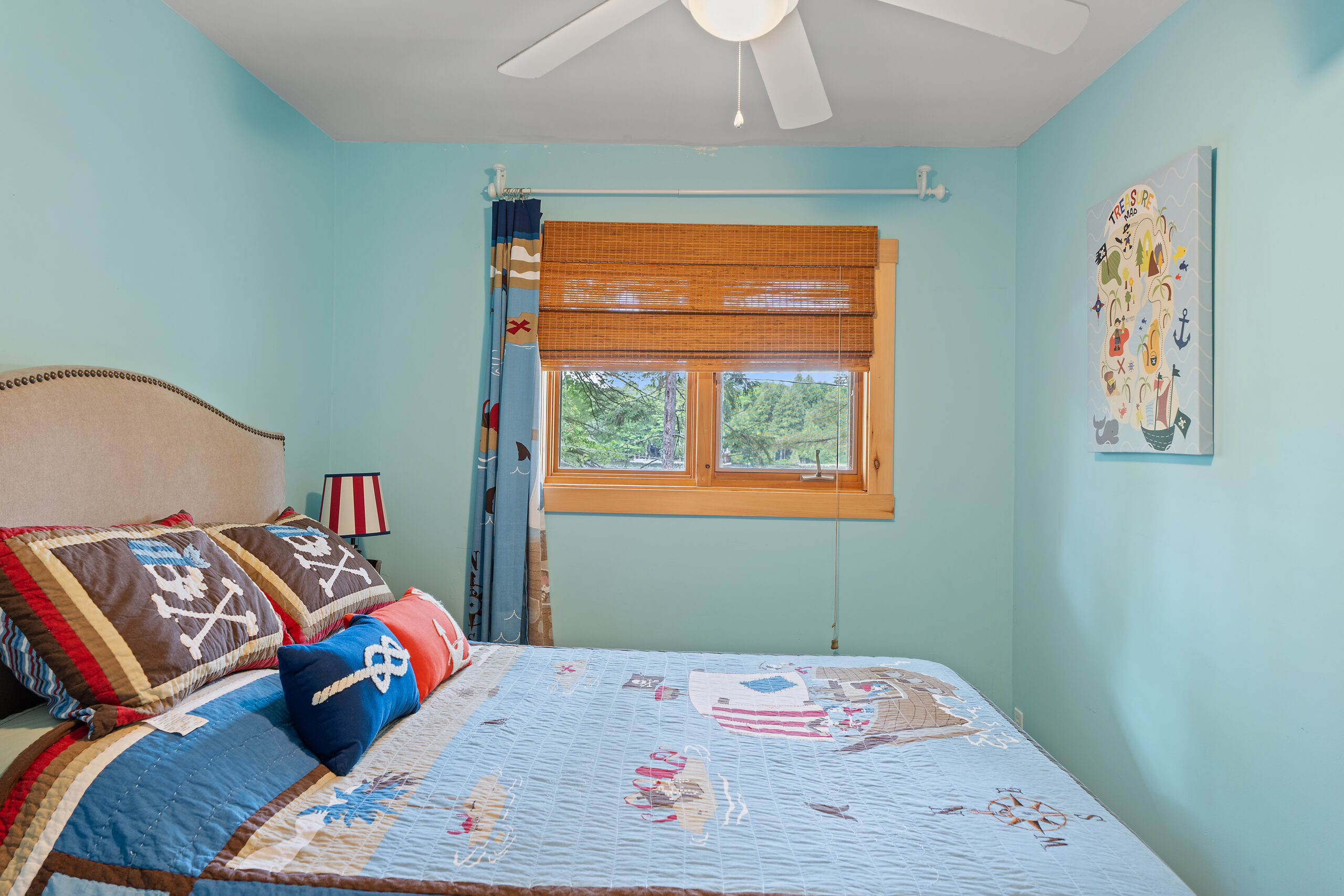 the side of the blue and red bed faces a wood-lined window