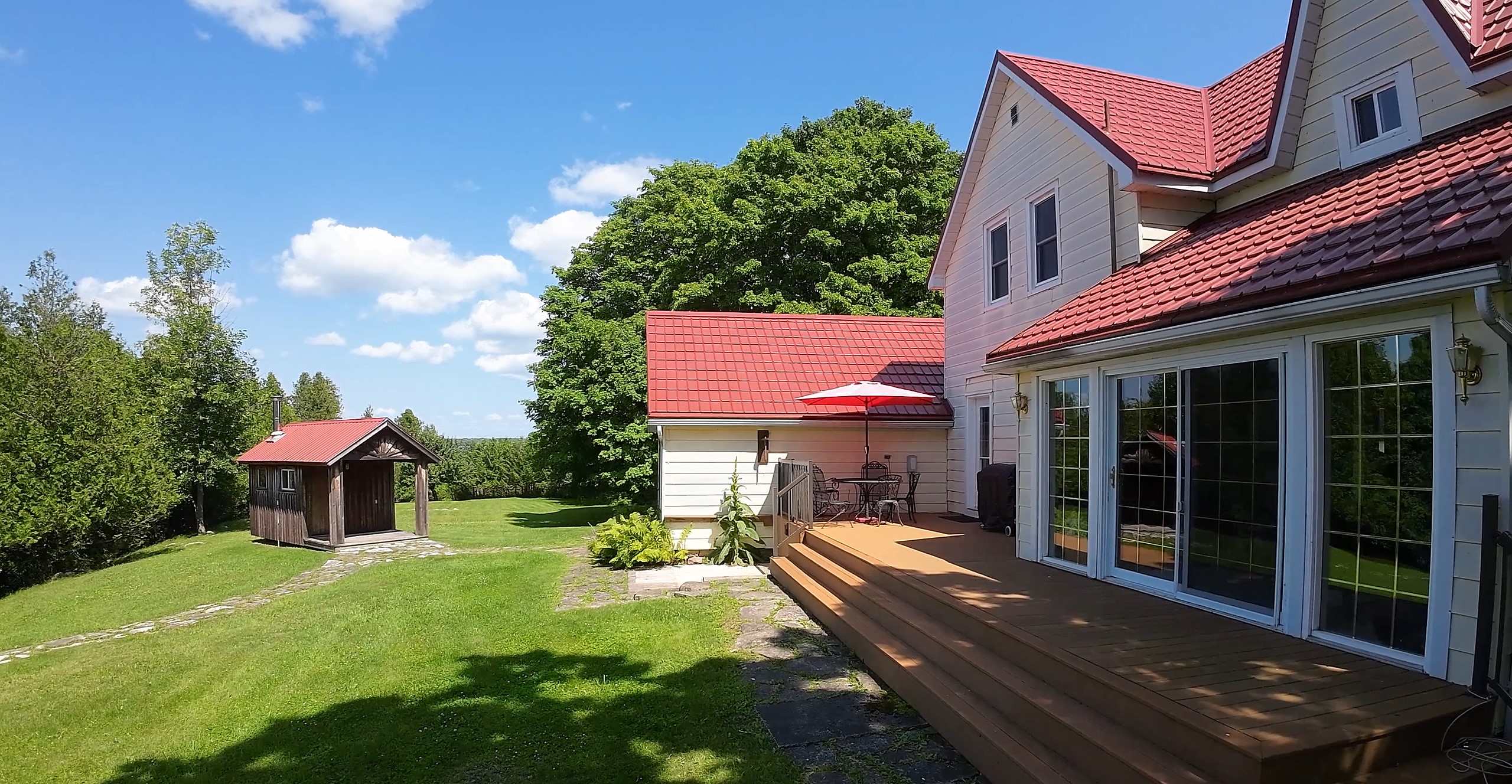 A brown deck on the back of the white house